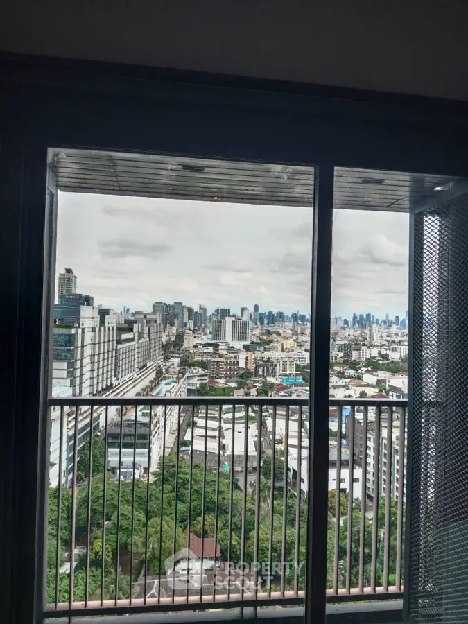 Stunning cityscape view from high-rise balcony with expansive skyline and lush greenery.