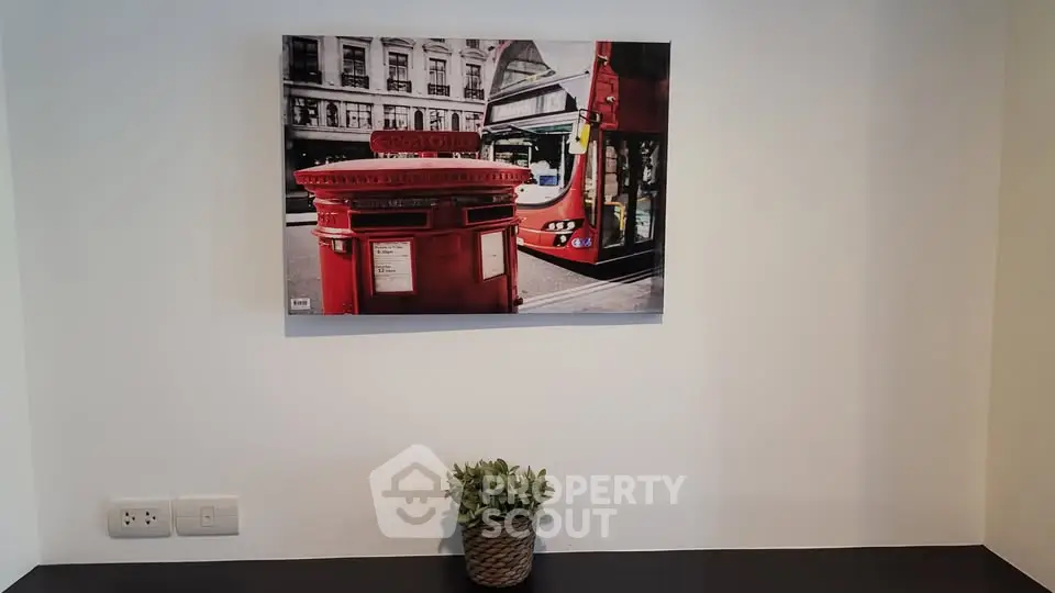 Modern interior with stylish wall art and potted plant on a sleek black shelf.
