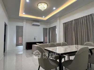 Elegant living room with modern chandelier and stylish dining area