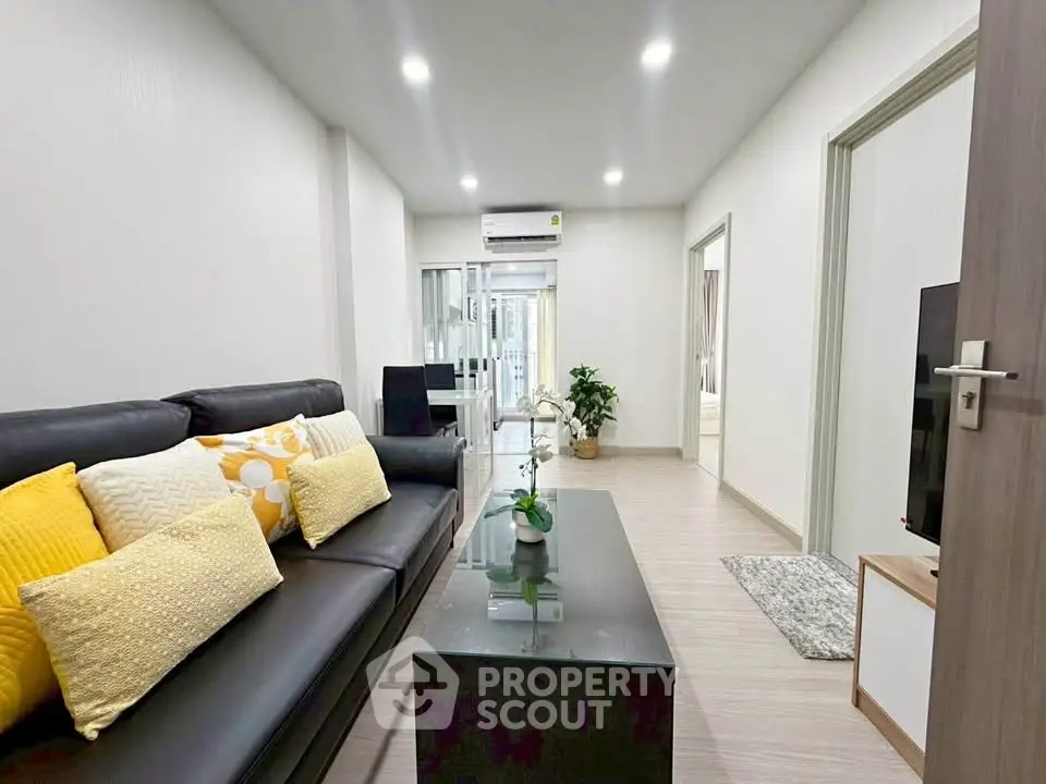 Modern living room with sleek black sofa and bright yellow accents, perfect for stylish urban living.