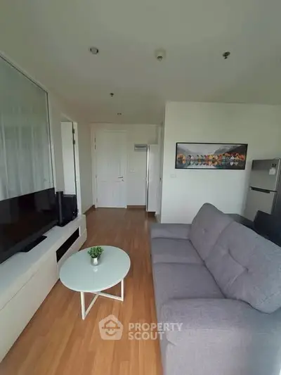 Modern living room with sleek furniture and wooden flooring in a stylish apartment.