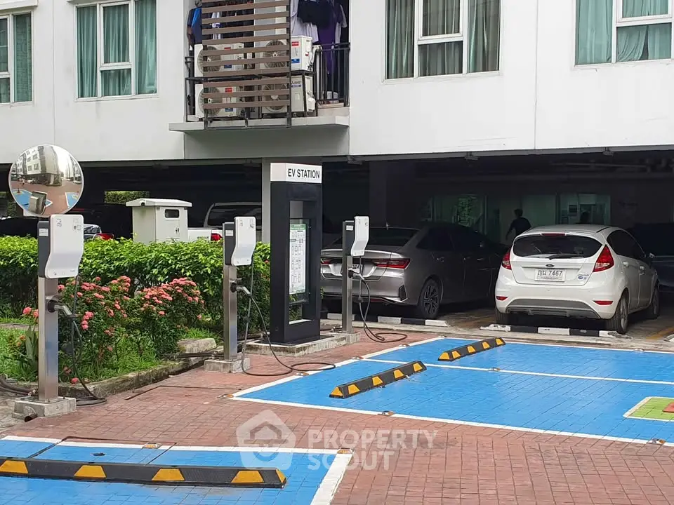 Modern apartment building with EV charging station and parking area