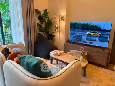 Cozy living room with modern decor, large TV, and lush greenery view.