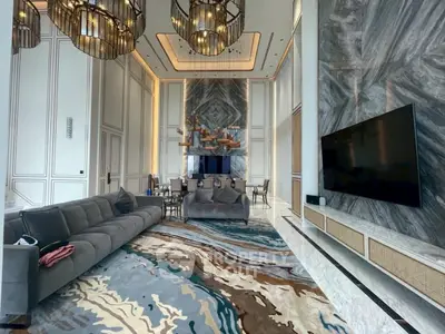 Luxurious living room with high ceilings, elegant chandeliers, and modern decor