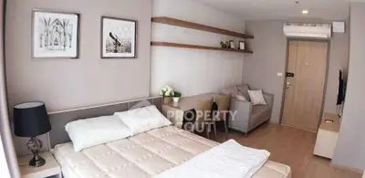 Modern studio apartment with cozy bed, stylish decor, and compact living area.