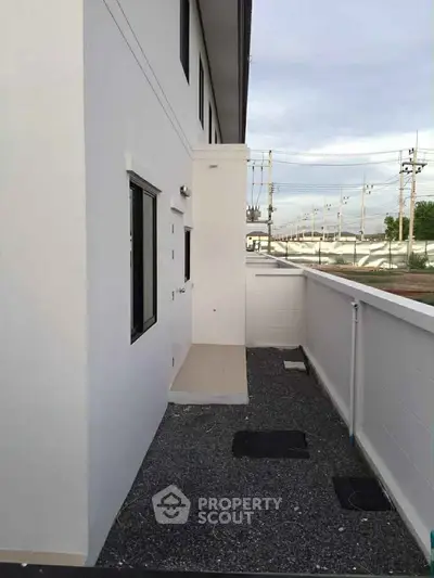 Modern exterior view of a minimalist building with clean lines and a small outdoor area.