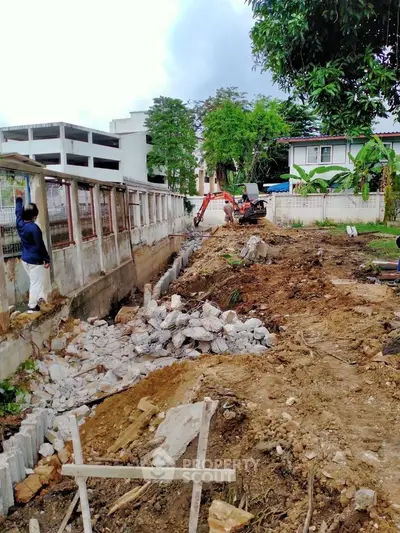 Construction site with rubble and machinery in a residential area