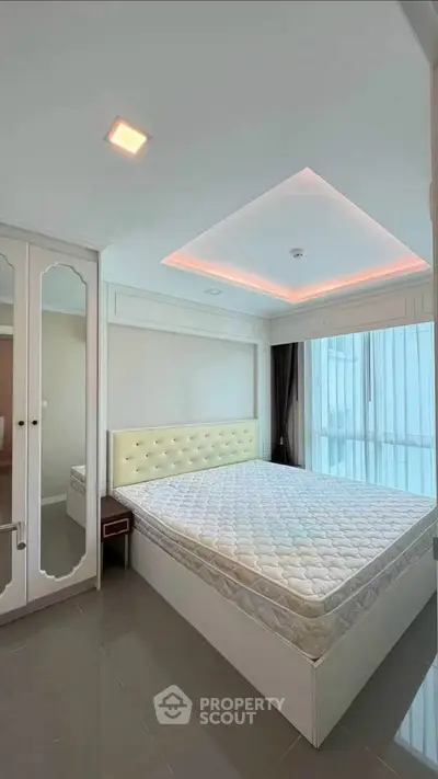 Spacious bedroom with modern design and large windows for natural light.