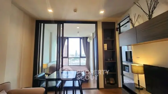 Modern open-plan living room with dining area and bedroom view.