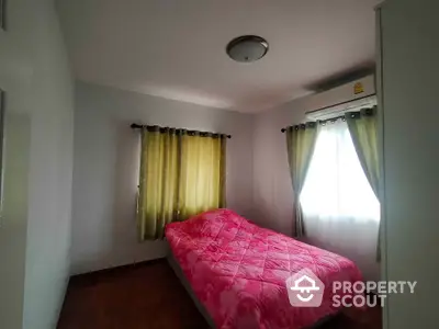 Cozy bedroom with pink bedding and natural light from two windows