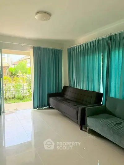 Bright living room with modern sofas and large windows overlooking garden