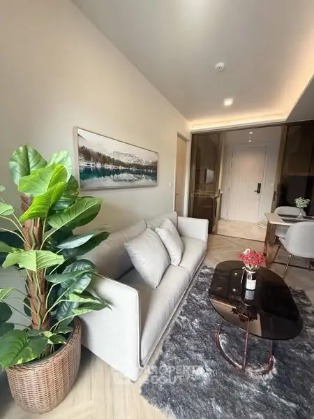 Modern living room with cozy sofa, stylish decor, and elegant dining area in open layout apartment.
