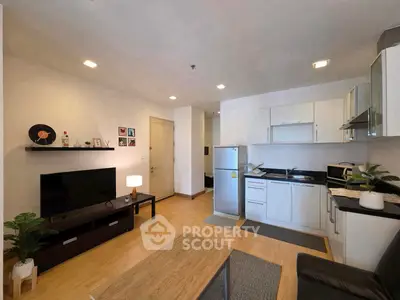 Modern living room with open kitchen, sleek furniture, and stylish decor in a cozy apartment setting.