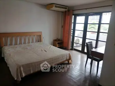 Spacious bedroom with balcony access and natural light in urban apartment