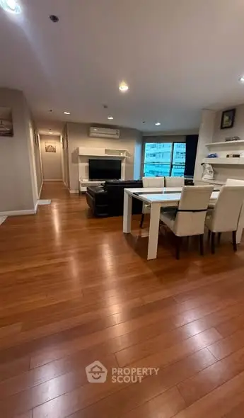 Spacious living room with elegant dining area and wooden flooring