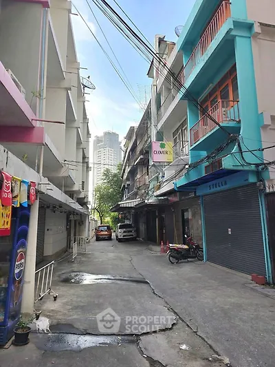 Charming urban alleyway with colorful buildings and parked vehicles, ideal for city living.