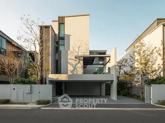 Modern architectural design of a luxury residential building with sleek lines and spacious driveway.