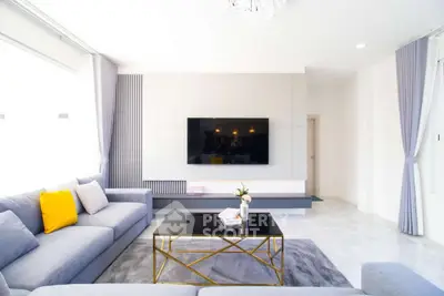 Modern living room with sleek design, large TV, and stylish furniture, perfect for relaxation and entertainment.