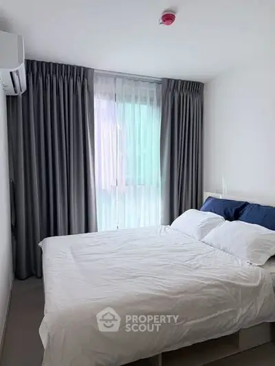 Cozy bedroom with modern decor and large window for natural light