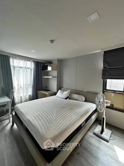 Modern bedroom with large window, stylish decor, and comfortable bed in a contemporary apartment.