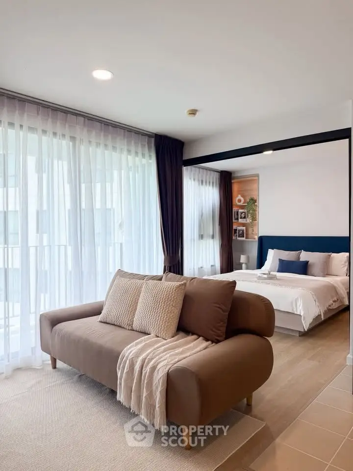 Modern living room with cozy sofa and elegant bedroom view