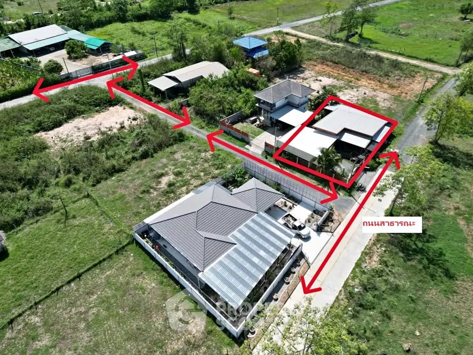 Aerial view of residential property with multiple buildings and green surroundings.