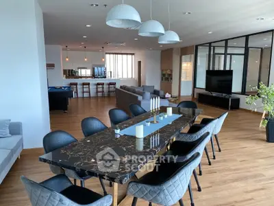 Spacious modern living room with elegant dining area and open layout, featuring stylish furniture and ample natural light.