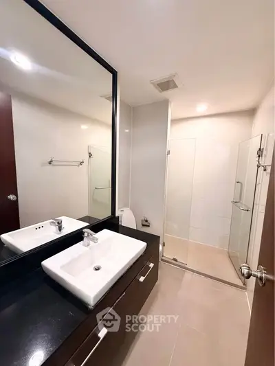 Modern bathroom with sleek design featuring a glass shower and stylish vanity.