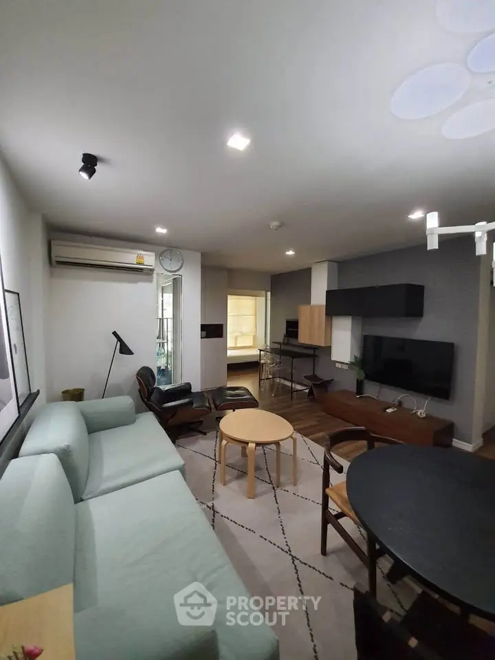 Modern living room with stylish furniture and open layout, featuring a cozy seating area and entertainment setup.