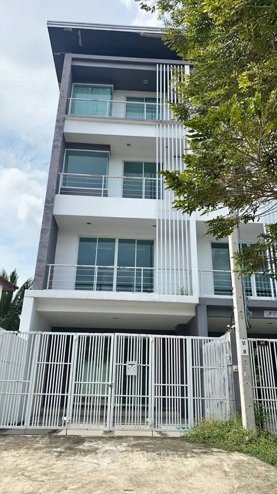 Modern multi-story building with sleek design and spacious balconies.
