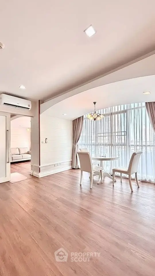 Spacious and bright living room with elegant dining area and large windows.