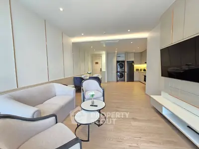 Modern living room with elegant furniture and open kitchen layout in a stylish apartment.
