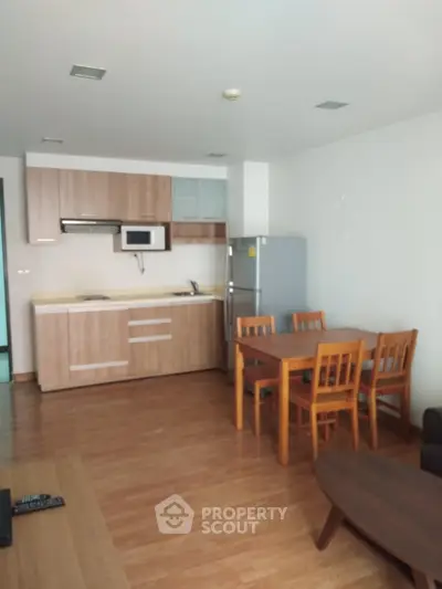 Modern kitchen with wooden cabinets and dining area in open layout apartment