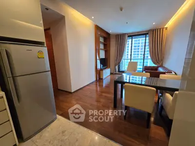 Modern living room with wooden flooring, dining area, and large window view in a stylish apartment.