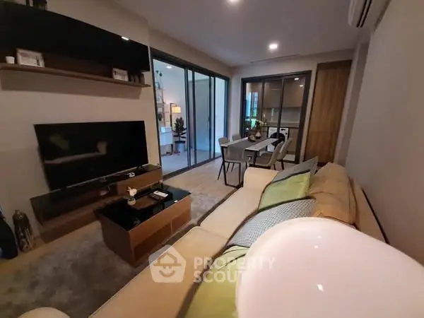 Modern living room with cozy seating and dining area, featuring sleek furniture and ambient lighting.