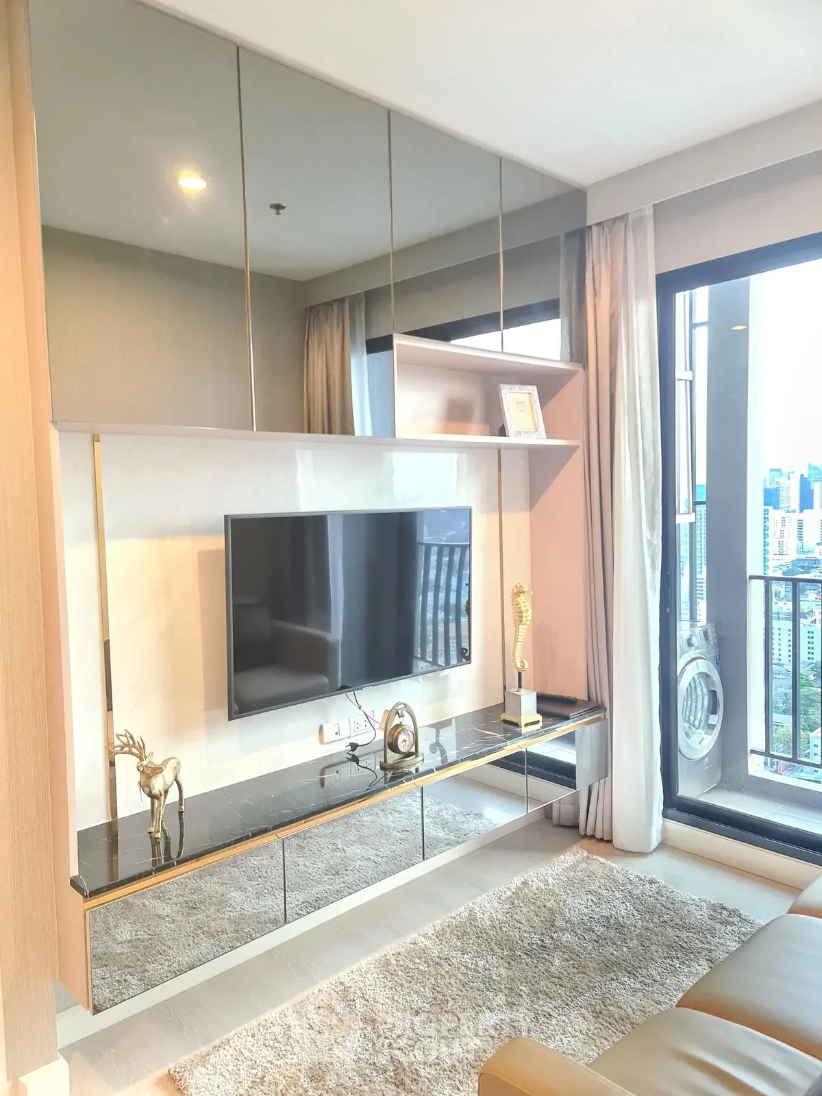 Luxurious living room with modern decor and stunning city view from large window.