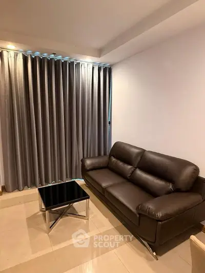 Modern living room with sleek leather sofa and stylish coffee table, perfect for urban living.
