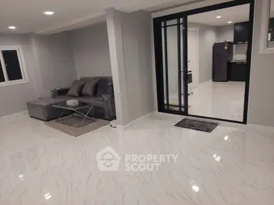 Modern living room with sleek marble flooring and open kitchen layout