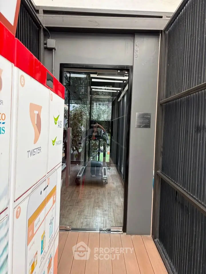 Modern gym entrance with sleek design and glass doors in a residential building.
