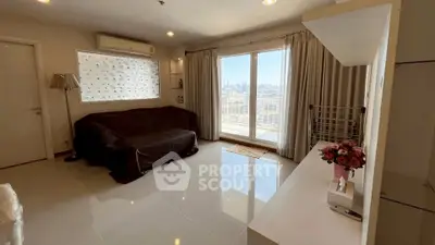 Spacious living room with city view and modern decor in high-rise apartment.