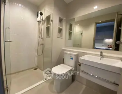 Modern bathroom with glass shower and sleek fixtures in a contemporary home.