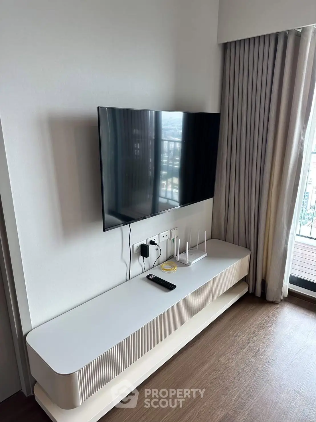 Modern living room with sleek TV setup and balcony view