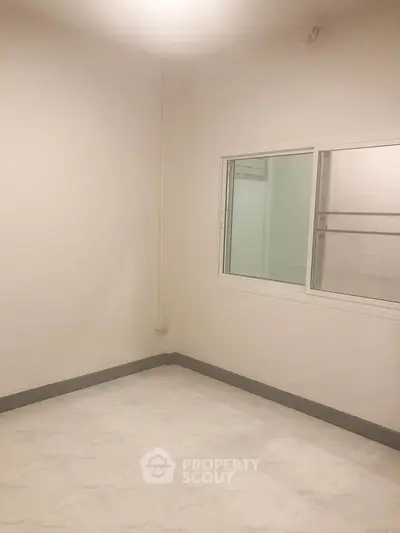 Spacious empty room with window and neutral walls, ideal for customization.