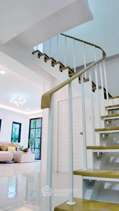 Modern spiral staircase leading to a bright living room with stylish decor