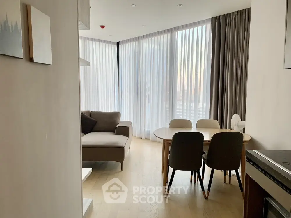 Modern living room with large windows and elegant dining area