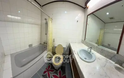 Spacious bathroom with bathtub and large mirror, ideal for relaxation.