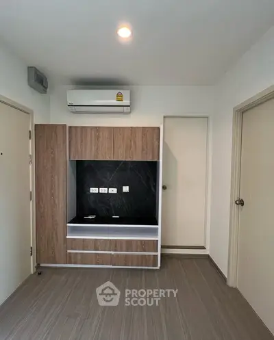 Modern minimalist kitchen with sleek cabinetry and air conditioning unit