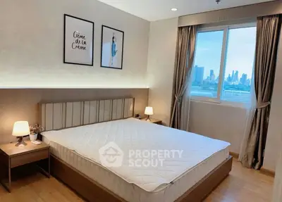 Modern bedroom with city view, stylish decor, and ample natural light.