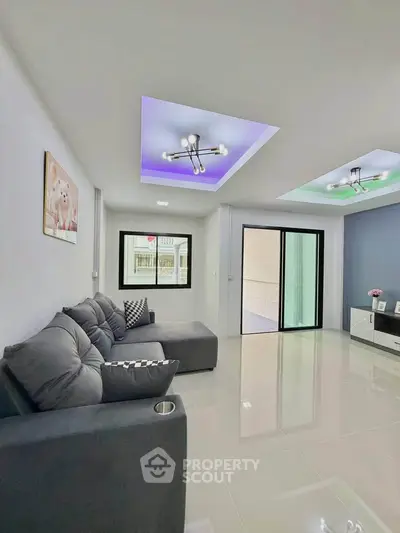 Modern living room with sleek design, featuring a cozy gray sofa and stylish ceiling lights.