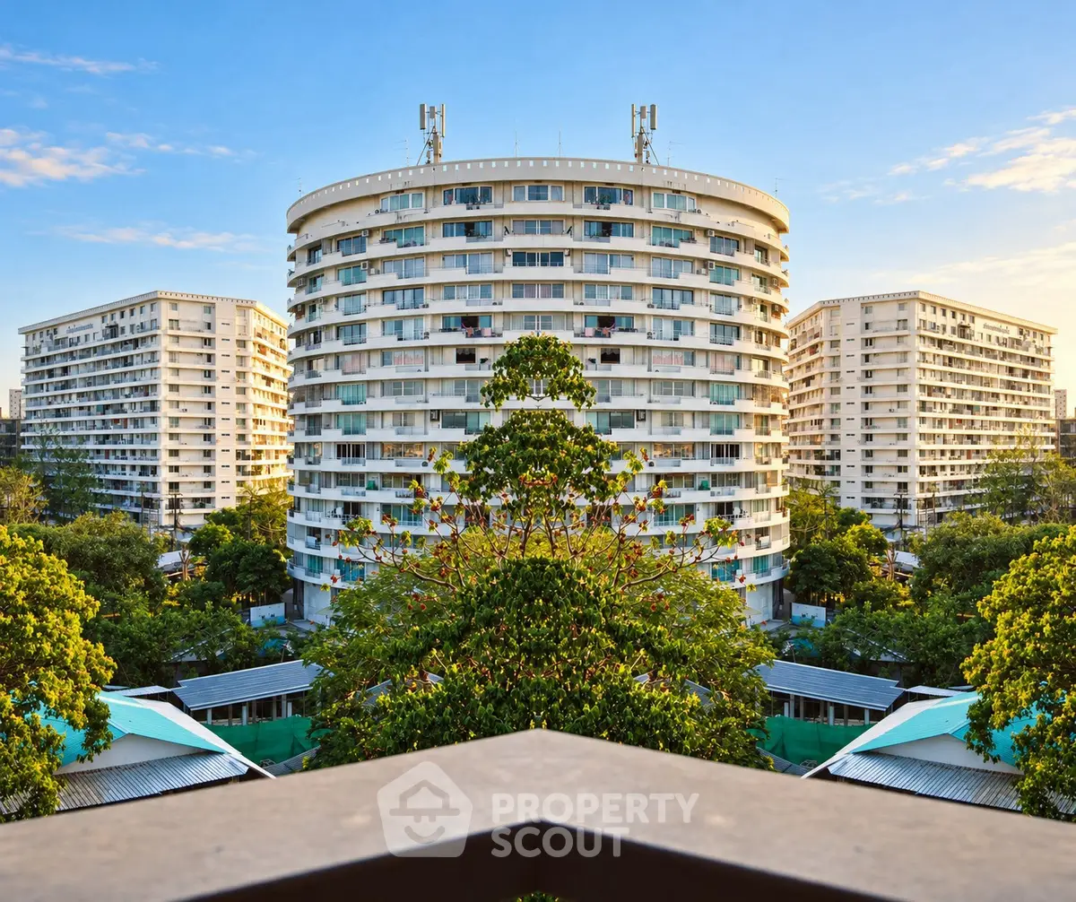 Stunning view of modern apartment buildings surrounded by lush greenery and clear blue sky.